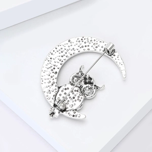 Silver crescent moon owl brooch showing the back pin fastener and hammered texture