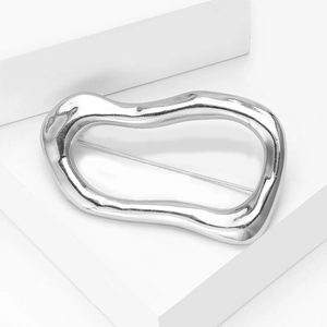 Macro detail of irregular silver liquid metal brooch with high polish finish