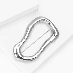 Macro view of silver irregular liquid metal brooch with polished lava texture and pin