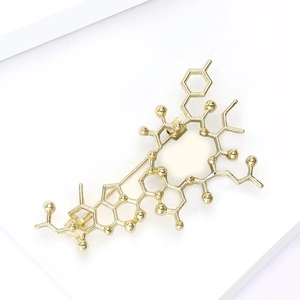 Close-up of golden chemical molecule structure brooch with polished metallic finish
