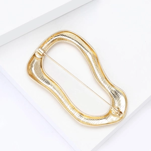 Golden irregular wavy brooch with brushed metal texture and secure pin closure