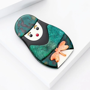 Détail de la broche poupée russe en acrylique avec fini vert émeraude et paillettes
