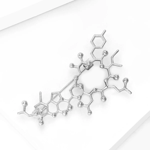 Silver chemical molecule brooch with elegant metallic structure on white minimalist background