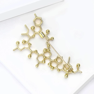Golden chemical molecule brooch pin for women with secure safety clasp on white background
