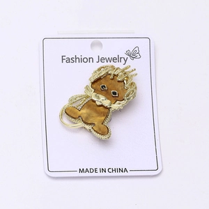 Détail d'une broche lion avec cadre doré, incrustation de marbre et yeux en pierre