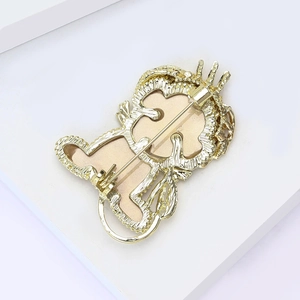 Broche lion dorée avec fermeture sécurisée sur un support géométrique blanc