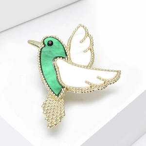 Exquise broche colibri dorée avec incrustations de nacre verte et blanche sur un socle
