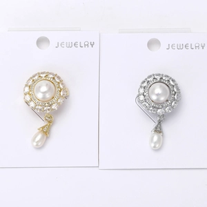 Detail of gold and silver flower brooches with freshwater pearls and zircon accents