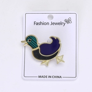 Macro detail of cartoon duck brooch with purple enamel and gold metallic edges