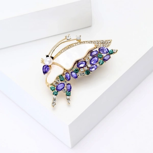 Détail d'une élégante broche papillon en or avec nacre et cristaux violets brillants