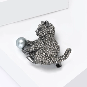 Détail de la broche chat en métal noir avec strass pavés et une perle grise élégante