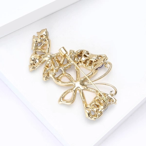 Elegant gold hollow butterfly brooch featuring a secure rotary safety pin clasp on the back