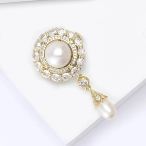 Detail of flower brooch with white pearls and sparkling zircons in gold setting