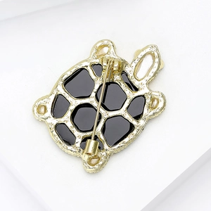 Exquisite gold-plated turtle brooch with black enamel finish and secure pin clasp detail