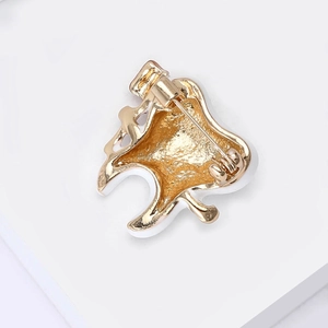 Back view of gold-tone creative tooth brooch with pin clasp and white enamel details