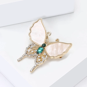 Elegant gold butterfly brooch with white shell wings, green gemstones and small diamonds