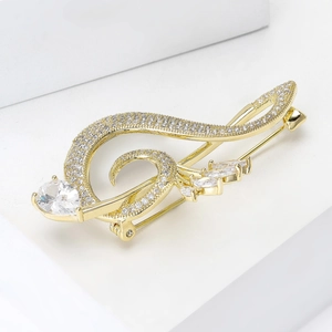 Detailed view of music note brooch with sparkling cubic zirconia and teardrop gem