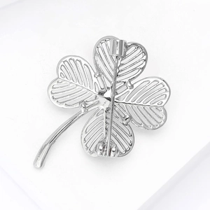 Macro view of silver four-leaf clover brooch showing back hollow structure and pin clasp