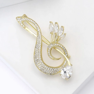 Detailed view of musical note swan brooch with sparkling zircons and gold plating