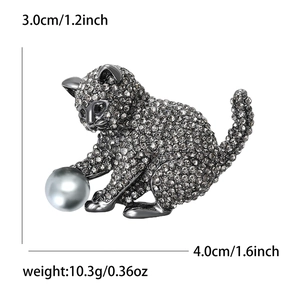 Broche chat élégante sertie de strass gris jouant avec une grande perle ronde