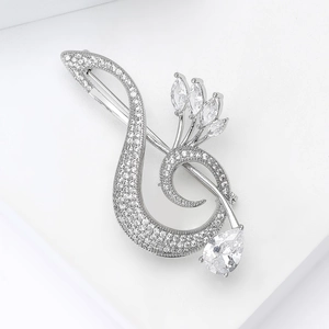 Detail of silver musical note brooch with sparkling zircon inlays for suit lapels