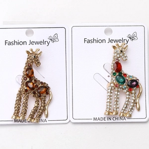 Dettagli ravvicinati delle spille a giraffa dorate con strass colorati e finitura lucida