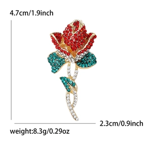 Élégante broche rose dorée avec strass rouges et verts et mesures de taille