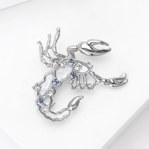 Dettaglio di una spilla a scorpione in argento con strass blu e smalto bianco