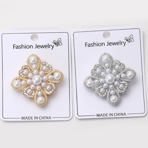 Detailed close-up of Baroque pearl brooches in gold and silver on display cards