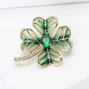 Macro shot of clover brooch featuring green enamel petals and sparkling crystal rhinestones