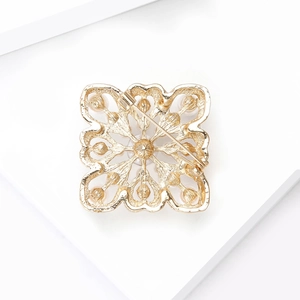 Back view of baroque pearl brooch in gold finish with hollow floral design and pin clasp