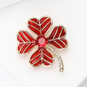 Macro shot of a red four-leaf clover brooch with ruby-style stone and cubic zirconia inlay