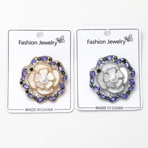Vue détaillée d'une broche rose en nacre avec perles d'eau douce et strass violets