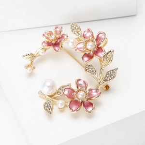 Detailaufnahme der Brosche mit rosa Emaille-Blüten, Perlen und kleinen Kristallen