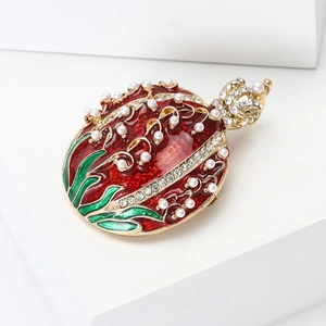 Macro detail of crown pomegranate brooch with red enamel, pearls and crystals