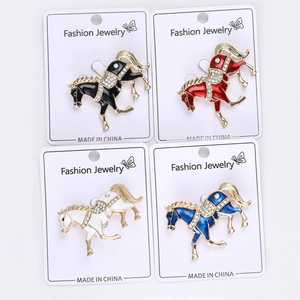 Detail of four colorful horse brooches with enamel finish and sparkling rhinestones