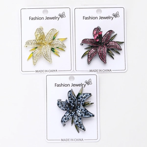 Detailed close-up of lily flower brooches set in gold, rose red, and dark blue colors