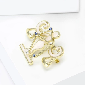Détail de la broche constellation Balance avec placage or, émail blanc et cristaux bleus