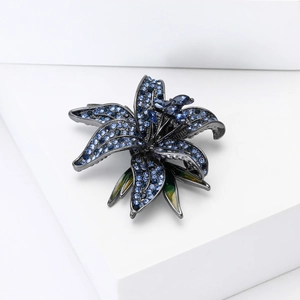Close-up of lily brooch featuring light blue micro-pavé diamonds and enamel leaf detail