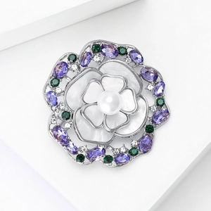Détails de la broche camélia en nacre avec perle d'eau douce et pierres violettes