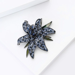 Macro detail of lily brooch with blue crystals and gunmetal plating texture