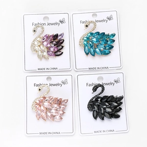 Detalle de cuatro broches de cisne de cristal en colores púrpura, azul, rosa y negro