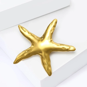 Broche étoile de mer dorée moderne avec texture métal liquide sur socle blanc