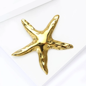 Détail du design de la broche étoile de mer dorée avec texture métallique liquide chic