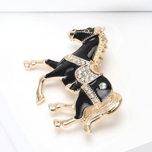 Detail macro shot of elegant enamel horse brooch with rhinestones in black and gold