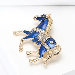Macro view of horse brooch with blue enamel inlay and sparkling white rhinestones