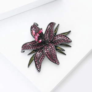 Close-up of lily brooch with pink rhinestones on black plated alloy flower petals