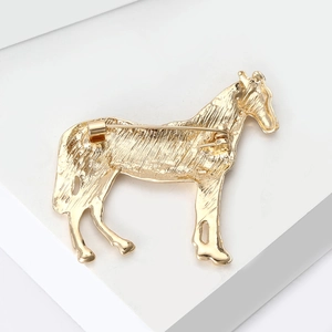 Rückansicht der goldenen Pferdebrosche mit Legierungsstruktur und Nadelverschluss