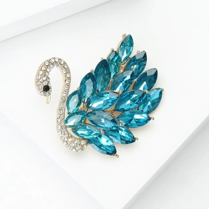 Detalle de broche de cisne dorado con gemas marquise azul mar y cristales brillantes