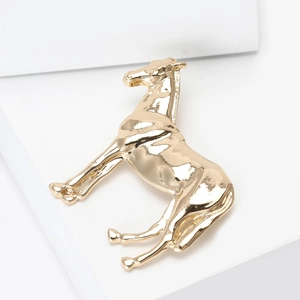 Detail einer polierten goldenen Pferdebrosche mit realistischer galoppierender Pose